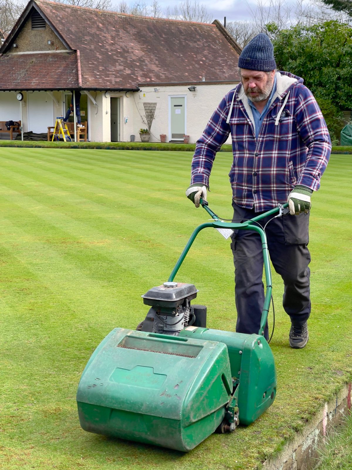 Groundskeeper mowing a lawn in Greater London